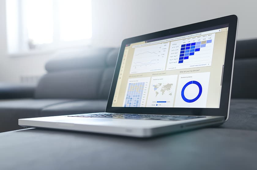 A laptop displaying business charts and analytics dashboards.